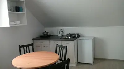 a kitchen with a wooden table and a small kitchen with a table and chairs at Atostogų namai in Druskininkai