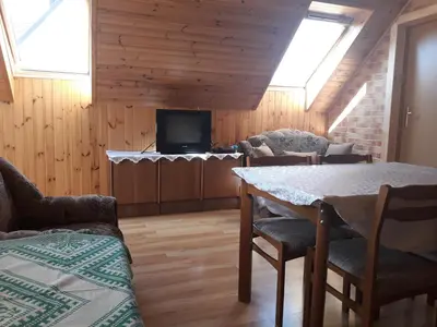 a living room with a table and a tv at Alyvos in Ignalina