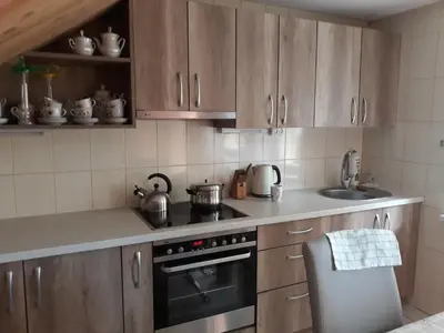 a kitchen with wooden cabinets and a stove and a sink at Alyvos in Ignalina