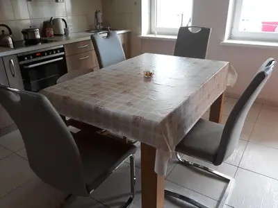 a kitchen with a wooden table with chairs and a table at Alyvos in Ignalina