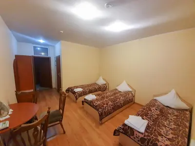 a room with two beds and a table and a table at Pasienis in Pasvaliečiai