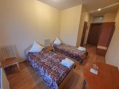 a small room with two beds and a table at Pasienis in Pasvaliečiai