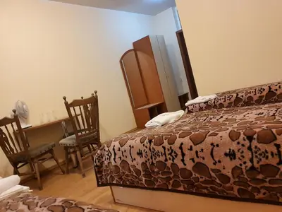 a bedroom with a bed and a desk and chairs at Pasienis in Pasvaliečiai