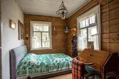 a bedroom with a bed and a desk and windows at Pagulbis - Tavo namai in Klabiniai