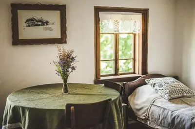 a room with a table with a vase of flowers on it at Pagulbis - Tavo namai in Klabiniai