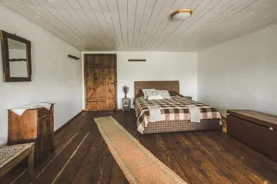 a bedroom with a bed and a wooden floor at Pagulbis - Tavo namai in Klabiniai