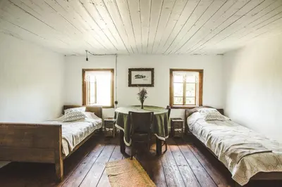 a room with two beds and a table in it at Pagulbis - Tavo namai in Klabiniai