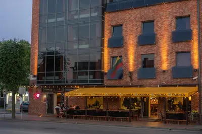 a building with a restaurant in front of it at Hotel Vaidila in Alytus