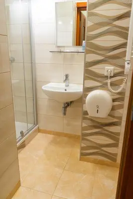 a bathroom with a sink and a mirror at Hotel Vaidila in Alytus