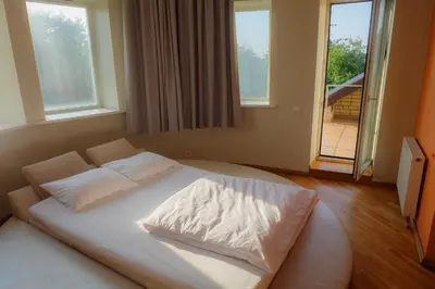 a bedroom with a white bed in front of a window at A&L private rooms in Kaunas in Kaunas