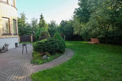 a garden with a bush next to a house at A&L private rooms in Kaunas in Kaunas