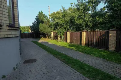 a sidewalk next to a fence next to a yard at A&L private rooms in Kaunas in Kaunas
