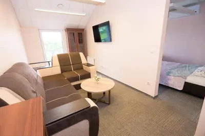 a room with a couch and a bed and a table at Rezidencija 