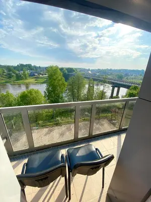 a balcony with two chairs and a view of a river at Rezidencija 