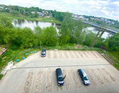 two cars parked in a parking lot next to a river at Rezidencija 