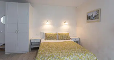 a bedroom with a bed and two night stands at Classic Old Town Apartment in Druskininkai