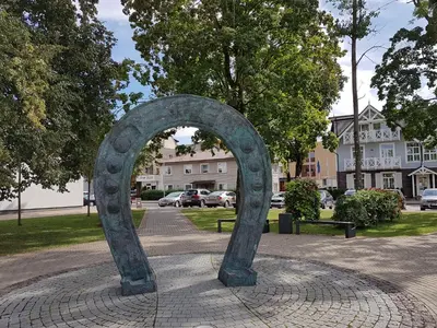 a sculpture of an arch on a brick sidewalk at Classic Old Town Apartment in Druskininkai