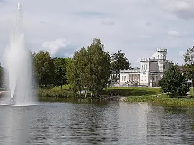 a fountain in the middle of a lake in front of a building at Classic Old Town Apartment in Druskininkai