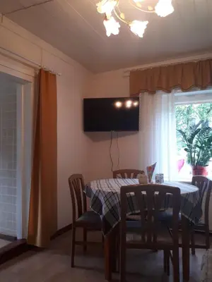 a dining room with a table and chairs and a television at Česlovos sodyba in Zarasai