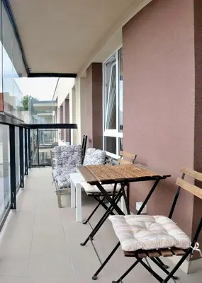a balcony with a wooden table and chairs at Dzuku apartment 40 in Vilnius