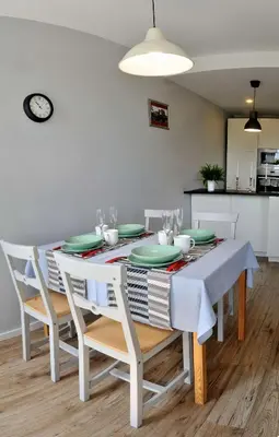 a dining room with a white table and chairs at Dzuku apartment 40 in Vilnius