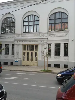 a white building with windows and doors on a street at Jolando Apartment in Kaunas