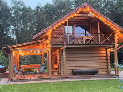a cabin with a deck with a table and chairs at Escape of city in Pabiržė