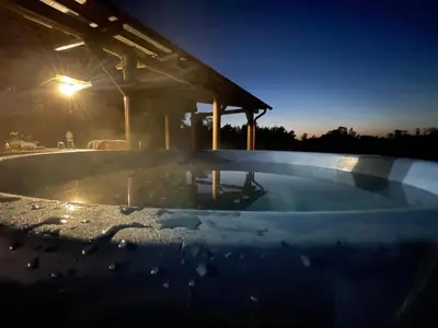a snow covered swimming pool at night with a building at Escape of city in Pabiržė