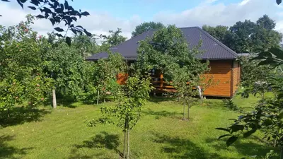 a log cabin in the middle of an apple orchard at Vasarnamis Zarasuose in Zarasai