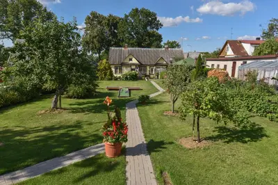 a garden with a house and trees and flowers at Vasarnamis Zarasuose in Zarasai