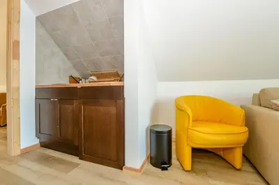 a yellow chair sitting in front of a desk at Vivaldi Lake House in Meteliai