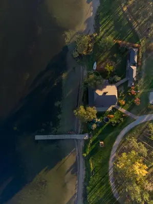 an aerial view of a house next to a river at Vivaldi Lake House in Meteliai