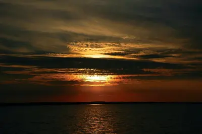 a sunset over a body of water at Vivaldi Lake House in Meteliai