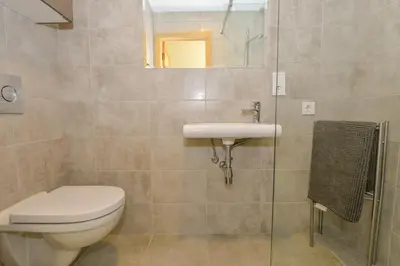 a bathroom with a toilet and a sink at Vivaldi Lake House in Meteliai