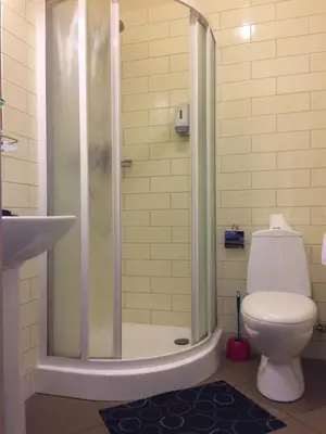 a bathroom with a shower with a toilet and a sink at Motel Paradise in Vilnius