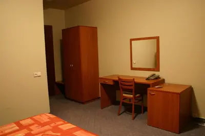 a bedroom with a desk and a mirror and a bed at Motel Paradise in Vilnius