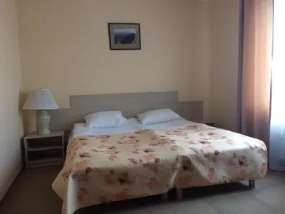 a bedroom with a bed with a flowered comforter at Motel Paradise in Vilnius