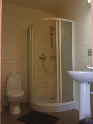 a bathroom with a shower with a toilet and a sink at Motel Paradise in Vilnius