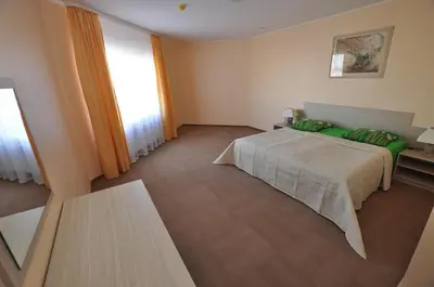 a bedroom with a bed with green pillows at Motel Paradise in Vilnius