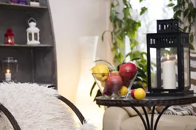 a table with a bowl of fruit and a candle at Drusva Apartamentai in Druskininkai
