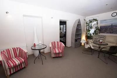 a living room with chairs and a table and a couch at Drusva Apartamentai in Druskininkai