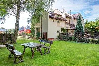 a picnic table and two chairs in a yard at Drusva Apartamentai in Druskininkai