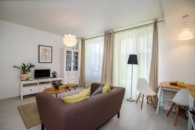 a living room with a couch and a table at #stayhere - Comfy & Stylish Studio with Green Patio close to Old Town in Vilnius