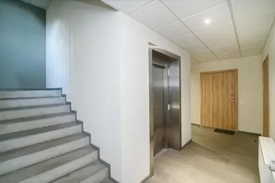 a hallway with stairs and a door in a building at #stayhere - Comfy & Stylish Studio with Green Patio close to Old Town in Vilnius