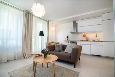 a living room with a couch and a table at #stayhere - Comfy & Stylish Studio with Green Patio close to Old Town in Vilnius