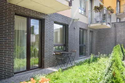 a patio with a table and chairs on a brick building at #stayhere - Comfy & Stylish Studio with Green Patio close to Old Town in Vilnius