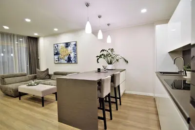 a kitchen and living room with a bar and a couch at Europa Dream Apartment in Vilnius