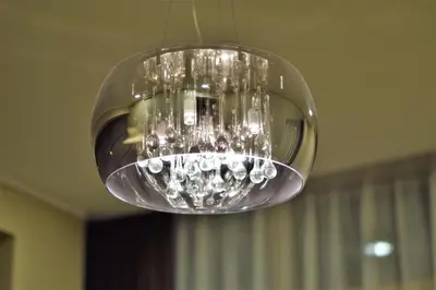 a clear glass chandelier hanging from a ceiling at Europa Dream Apartment in Vilnius