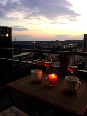 a table with two glasses of wine and a candle at Europa Dream Apartment in Vilnius