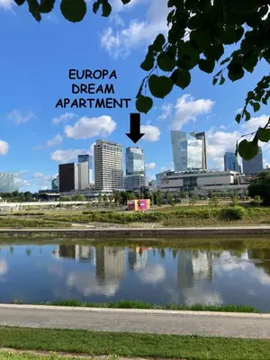 a view of a city skyline from a pond at Europa Dream Apartment in Vilnius